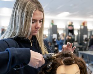 A student curls hair