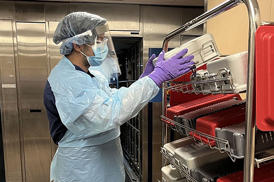  A student in scrubs handling equipment