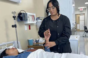 A CNA student takes a pulse