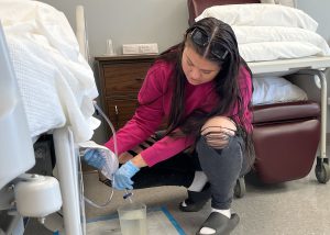 Nursing student checking a cath bag