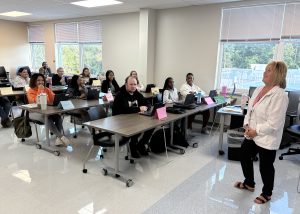 A teacher smiles while lecturing adults