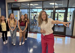 Counselor Jen Crave directs students in the lobby