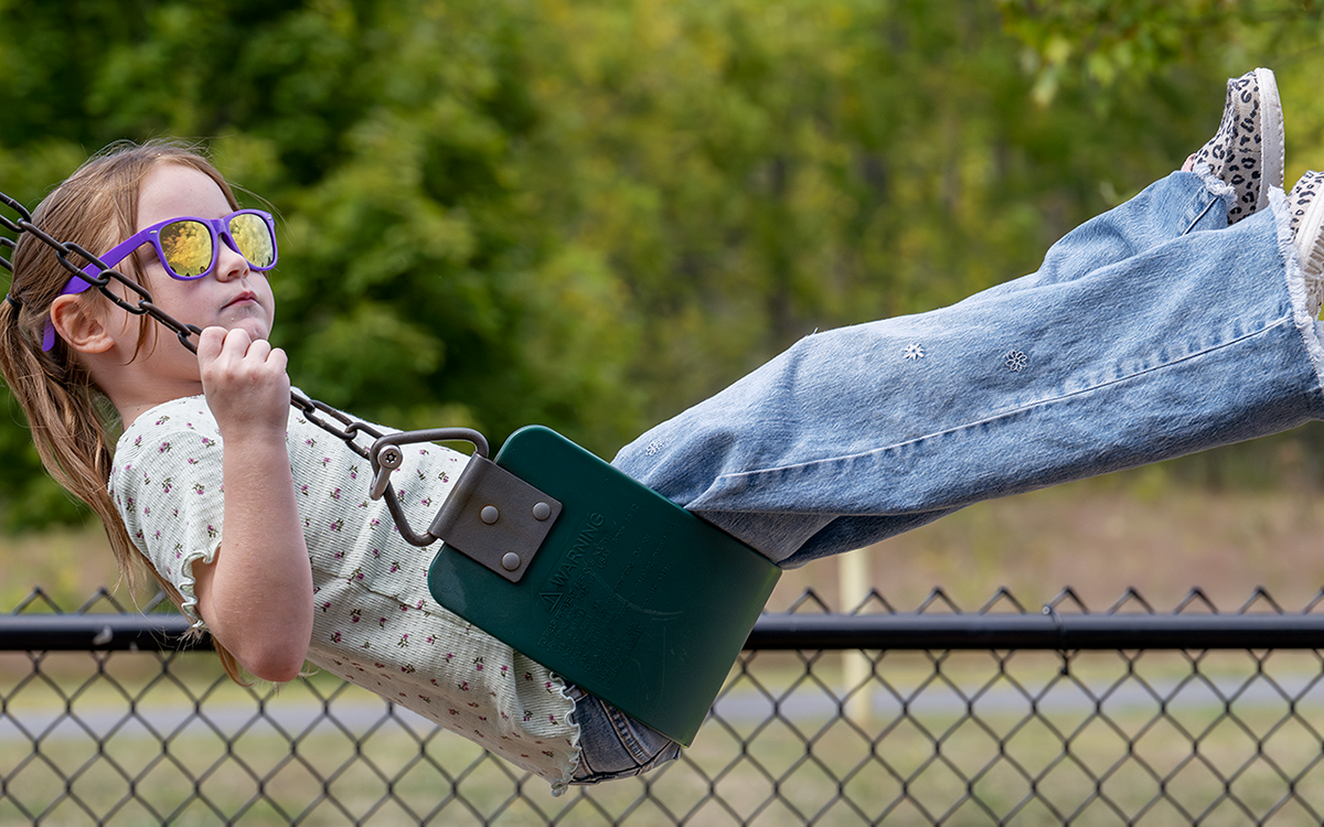 Close up photo of a young student on a swing at Airline Academy.