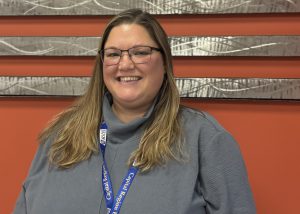 Person poses in front of metal flag
