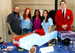 Regent and CTE contingent pose behind a table
