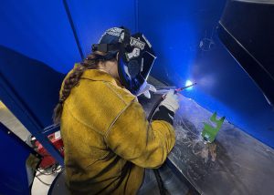 A female student welds