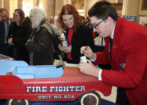 Student paints a truck as a guest looks on