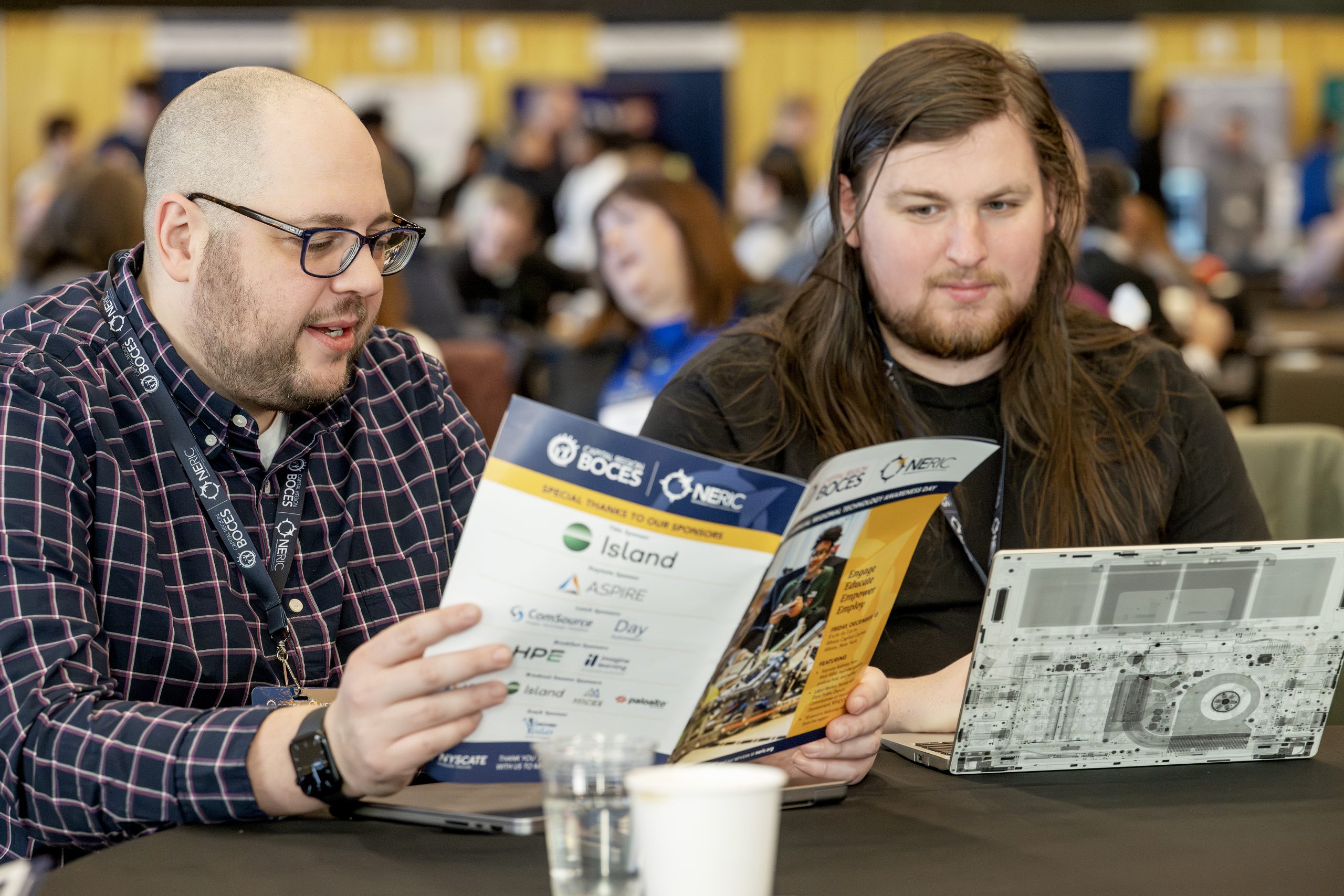Two people review the program for Tech A-Day