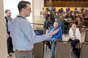 A man speaks to people who are seated