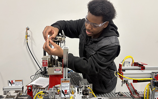 Student works on a robotic arm