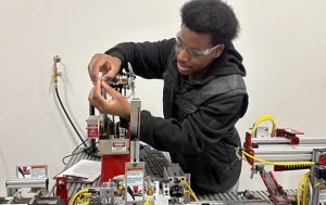 Student works a robotic arm