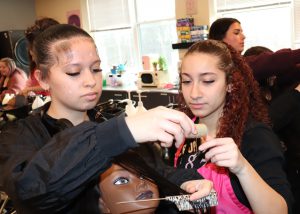 Student helps a prospect with hair