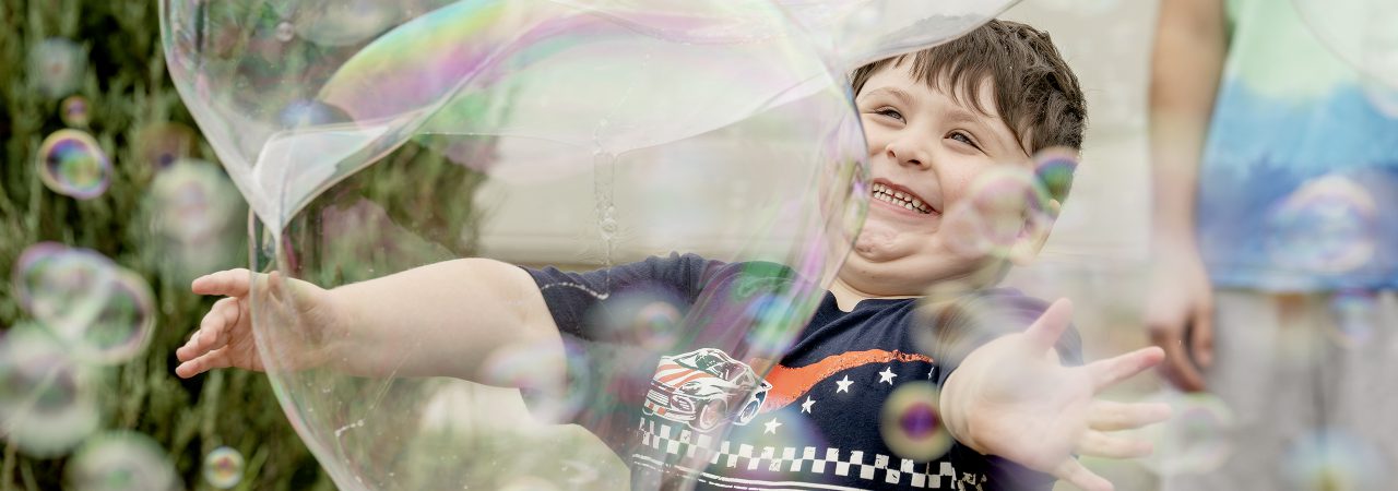 Teachers and a student walk from a bus into school.