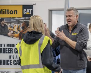 two adults near a CAT industry sign