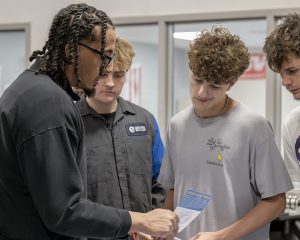 (L-R) Mick Hawkins senior of South Colonie in Auto Tech, Kaiden Branch senior of Shenendehowa in Auto Body, and Brad Bova senior at Cohoes in Auto Body, talk with Thruway Authority employee Marcello Santana at CRB Career Fair at Capital Region BOCES in Colonie on Thursday, March 19, 2026.