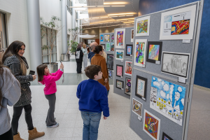 Students and their families observe and take photos of the artworks on display during the annual Capital Region BOCES Student Art Show reception.
