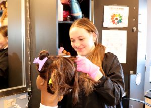 student smiles while styling