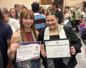 two students pose and smile