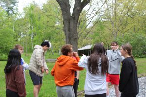 A group of students laughing and having conversations in sign language at the picnic.
