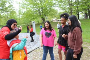 A teacher and students gather on the playground and speak in sign language during the picnic.