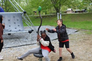 Two students having fun at the playground during the picnic.