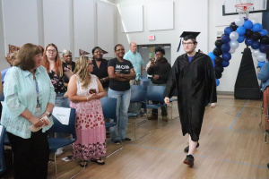 Maywood Academy graduate Vincent Malinowski walks down the aisle during the graduation ceremony on June 12.