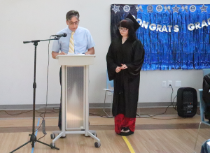 Graduate Alexis Bleyman accepts her certificate from her teacher John Best.