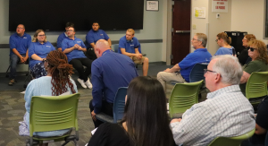 SELFI students are photographed wearing their royal blue SELFI Program t-shirts while sitting in front of an audience of supporters at their graduation and end-of-year celebration.