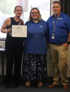 Lynn Fraim holds her Friend of the Program award as she stands next to SELFI Program student Skylar Britton and teacher Brent Pierce.
