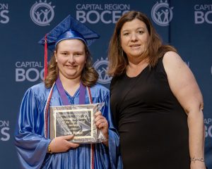 Lydia Waage poses with plaque and teacher