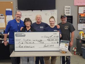 Student, faculty and staff pose behind fake check
