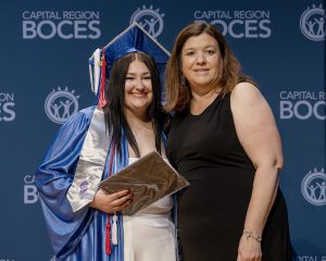 Student and faculty member pose with award