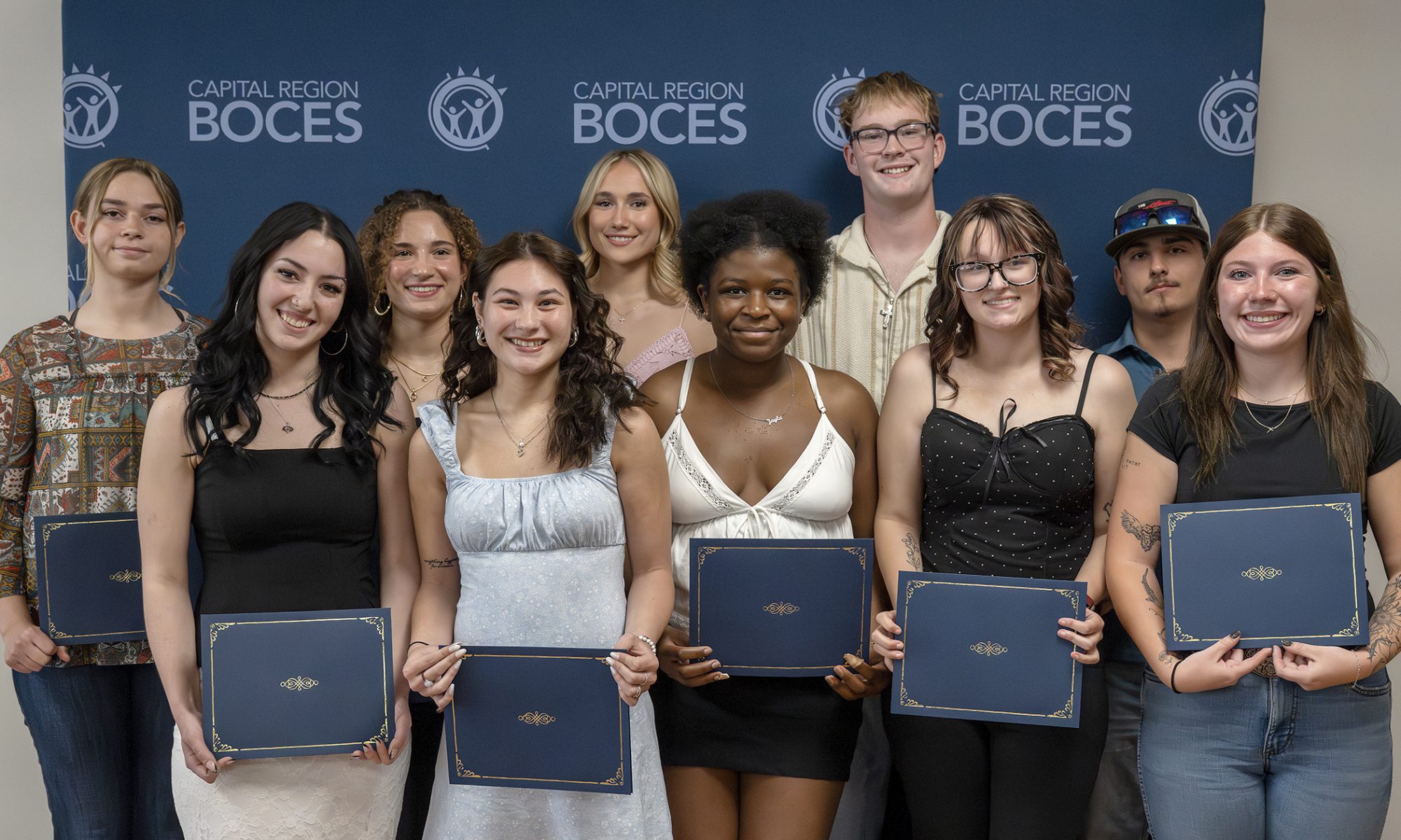 Students pose holding their awards