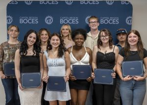 Students pose holding their awards