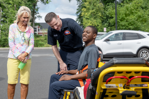 A student smiles as he enjoys a demonstration by a local EMS provider.