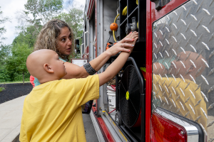 A student and teacher are photographed as they observe a fire truck.