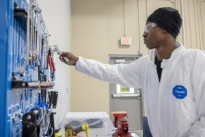 Student in white sterile suit making connections