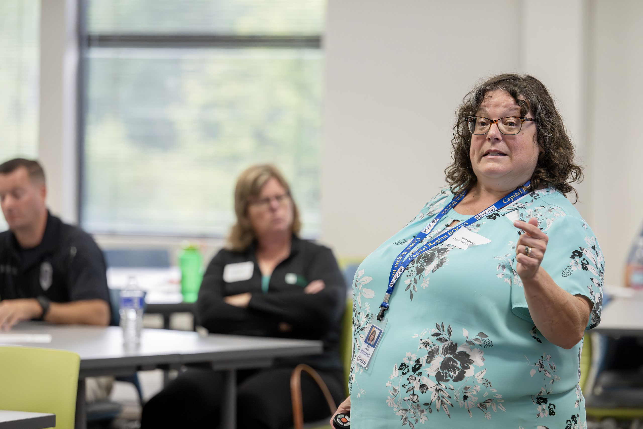 A woman is speaking at the head of a conference room