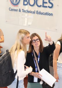 A teacher directs a student in the hallway