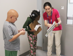 Special Education Teacher Christina Tschantret helps two her students solve a clue during a school-wide Scavenger Hunt.