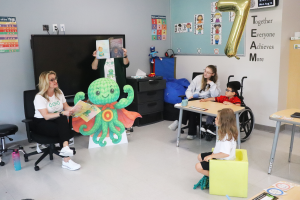 Jennifer Hendricks-Fogg reads to her son and his classmates.