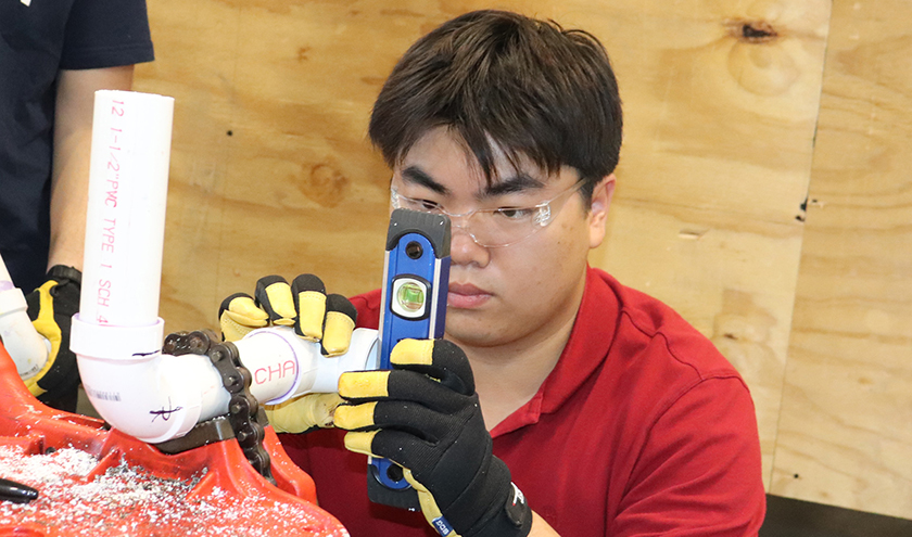 Sparks fly as a welding student works on a piece of metal.