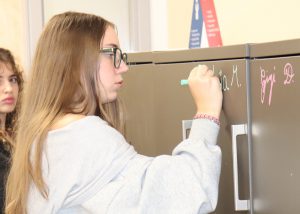 A girl write on a locker