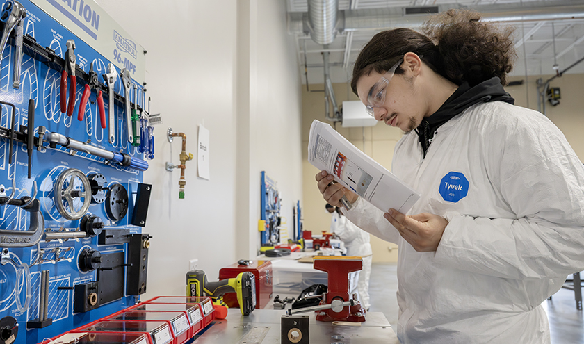 A CTE student wearing protective eyewear works on a metal project.