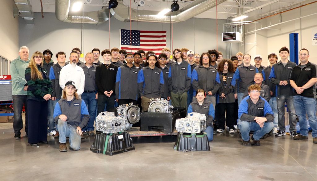 Students pose with dealer and equipment