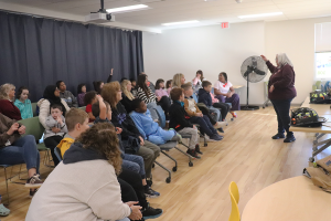 Airline Academy Drive elementary school students and their teachers are seated as Teaching Assistant Natalie Powell stands in front of the group to introduce Verdoy firefighters.
