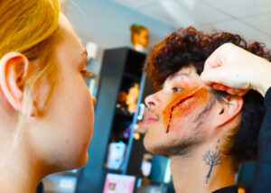 A guy gets a makeup scar on his cheek