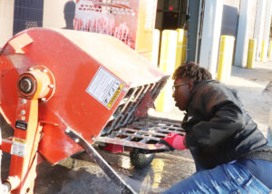 Student scrapes a cement mixer