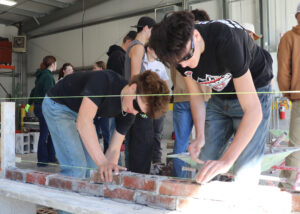 Students lay bricks