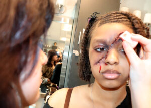 Student paints a scar on a face